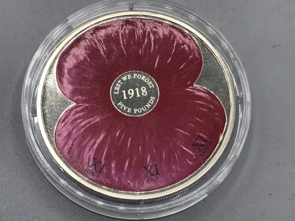2008 Jersey £5 “Lest We Forget” commemorative coin featuring a red remembrance poppy design.