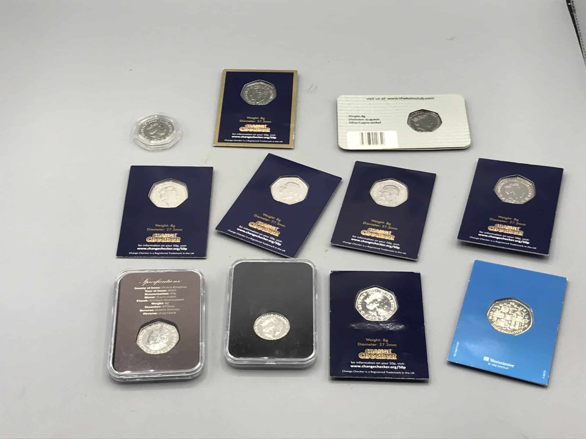 Assorted uncirculated UK 50p themed coins from 2020–2022 in original mint cards and capsules, reverse display view