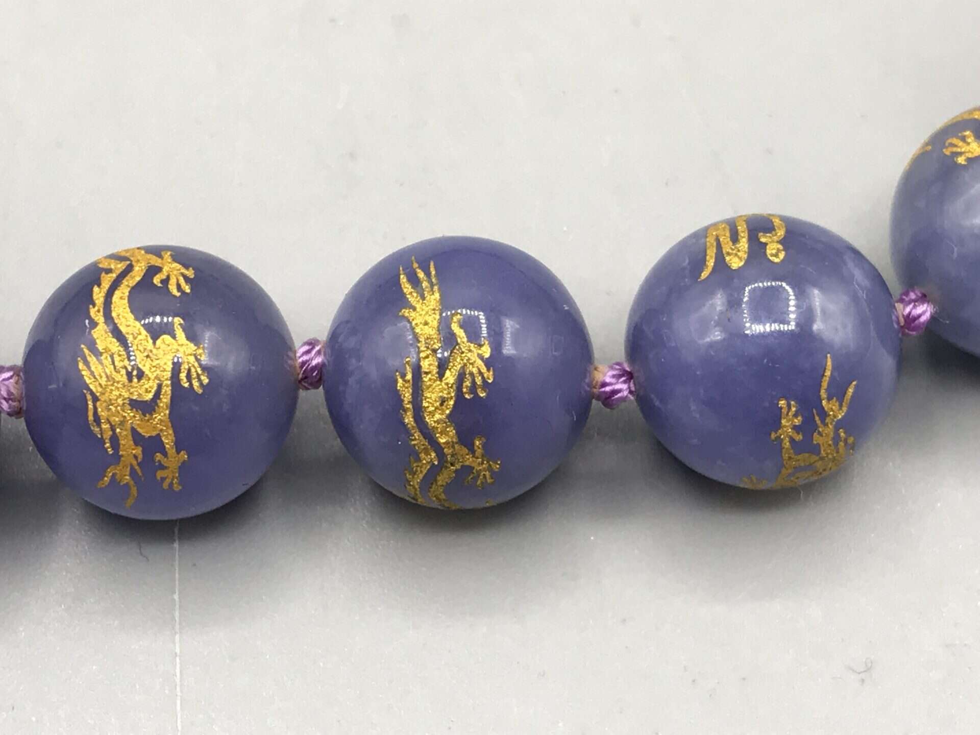 Coiled purple jade bead necklace with gold dragon designs