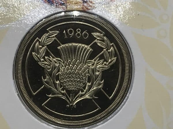 Close-up of the reverse design on the 1986 Royal Mint £2 coin, featuring a detailed thistle surrounded by a laurel wreath on the St Andrew’s Cross