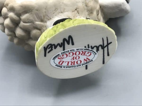 Underside of Grogg Shop sheep figurine base showing John Hughes signature and original Grogg Shop label.
