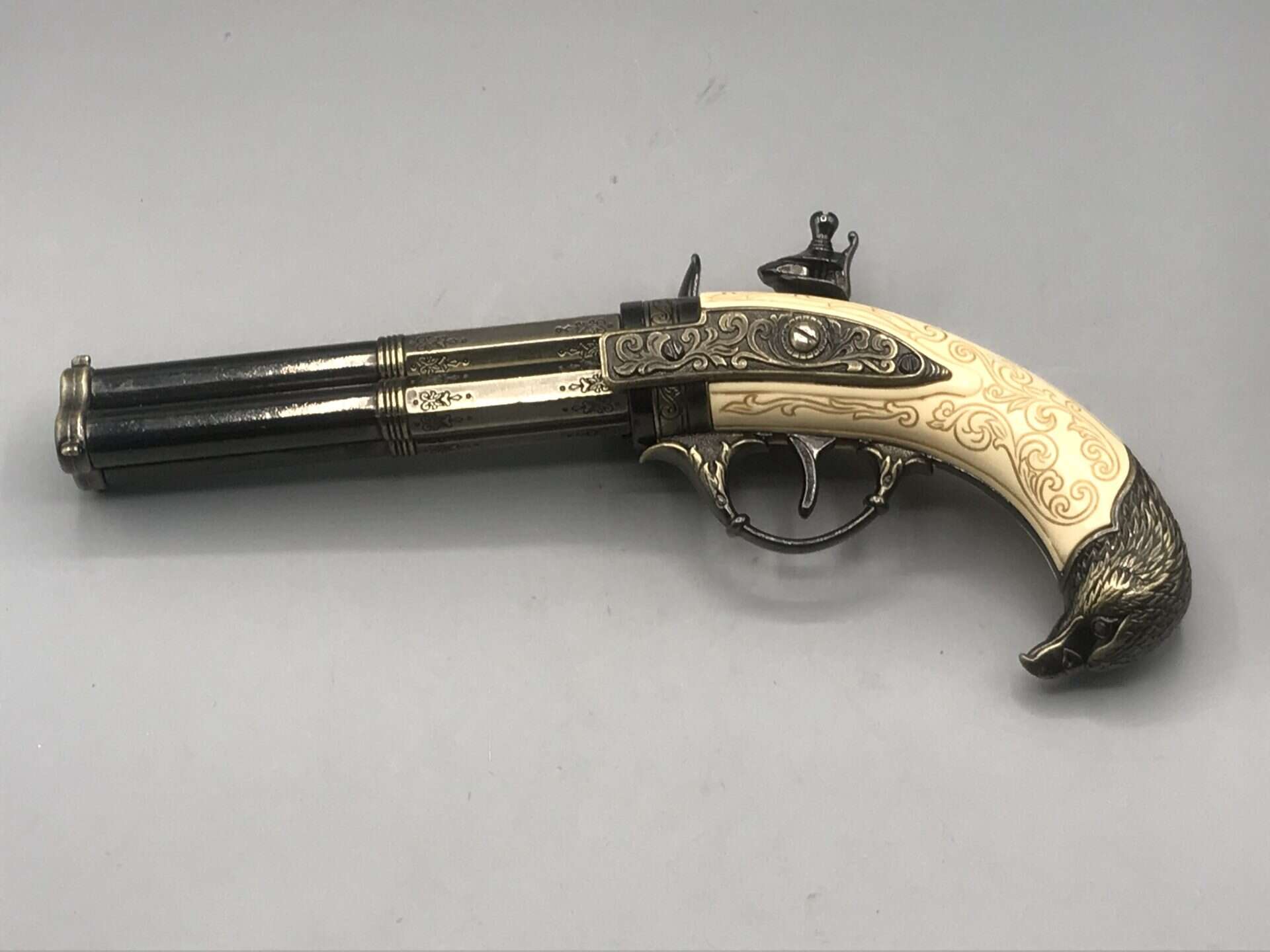 Rear view of replica 18th-century flintlock pistol showing grip, trigger guard, and barrel alignment.