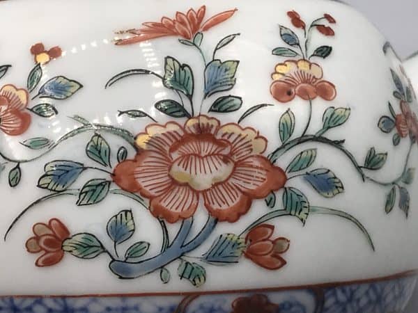 Close-up of famille verte floral decoration on 18th century Kangxi Chinese porcelain teapot with red, green, and cobalt blue enamels