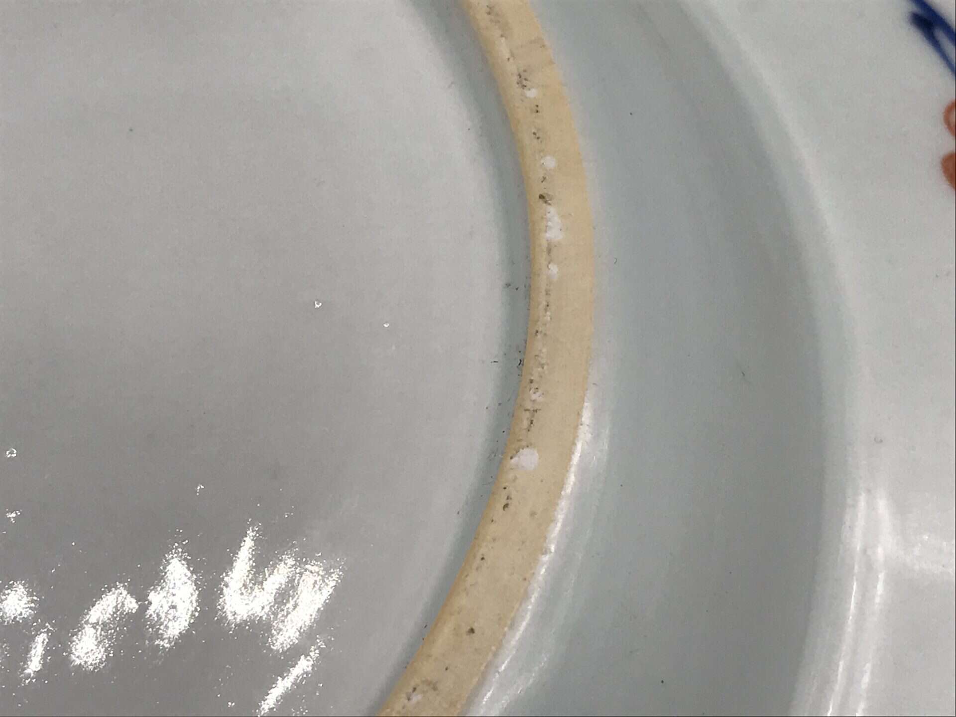 Close-up of footrim on 18th century Chinese export porcelain plate, Imari style, showing unglazed base and porcelain body from Jingdezhen kilns