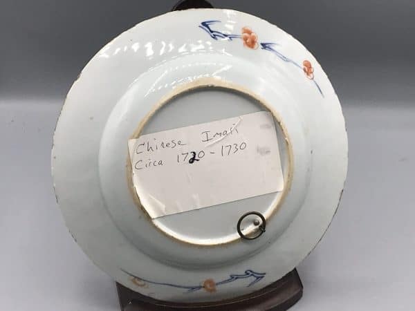 Back view of 18th century Kangxi Chinese Imari porcelain plate, showing plain glaze with floral sprays and old collector’s label, 8.5 inches diameter