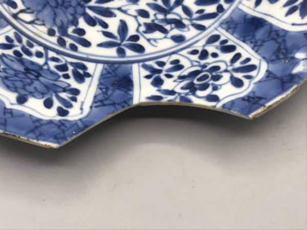 18th century Kangxi Chinese porcelain plate showing missing rim section, blue and white floral design circa 1700