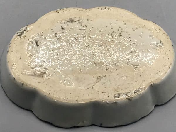 Underside of 18th century Chinese export porcelain dish, Qianlong period, showing unglazed base with firing grit and wear from age