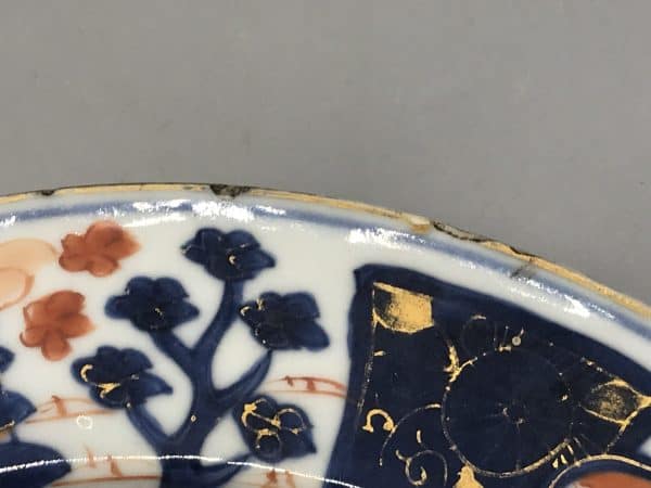 Side view of 18th century Kangxi Chinese Imari porcelain plate edge, showing rim fretting and age-related wear to glaze