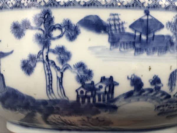 Close-up detail of 18th century Chinese export porcelain tureen, Qianlong era, showing blue and white riverside landscape with distant buildings and trees