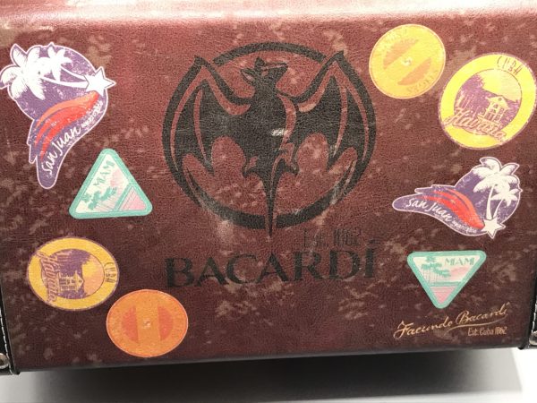Top view of vintage Bacardi suitcase ice box cooler with bat logo and travel sticker design