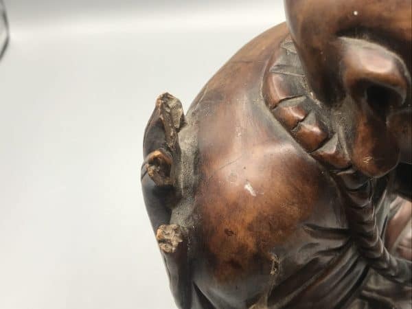 Detail image of antique Chinese carved hardwood Buddha statue showing damage with loss to right hand and base area