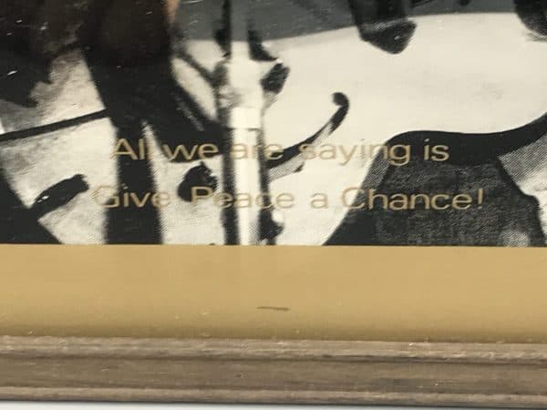Close-up of 1980s John Lennon mirror showing the quote “All we are saying is give peace a chance” printed in gold text on glass