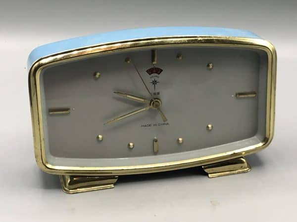 Mid-century Polaris Chinese mechanical alarm clock in blue metal case with gold trim and minimalist dial