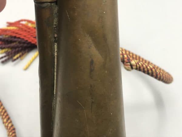 Close-up of small dent on antique brass and copper Royal Welch Fusiliers bugle