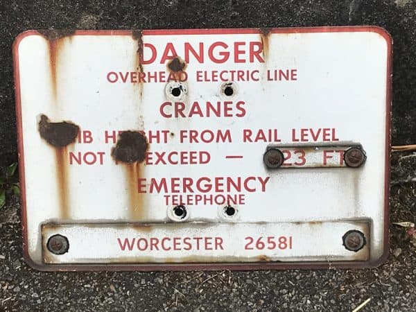 Alternative front view of antique enamel railway warning sign, mid-20th century industrial hazard notice in red and white with visible rust and wear