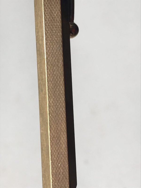 Close-up of mid-century British rolled gold pencil showing fine wave-patterned guilloché engraving