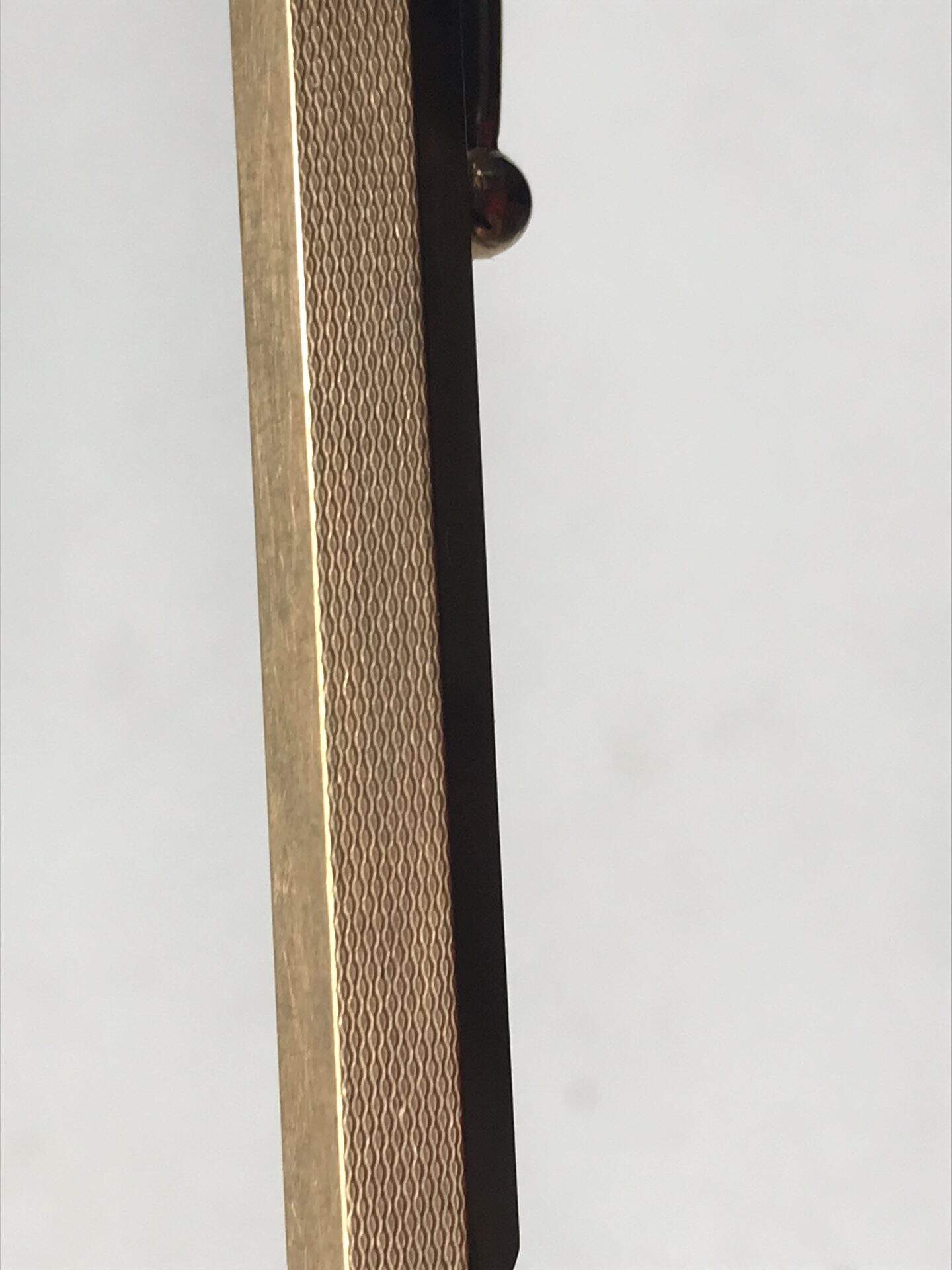 Close-up of mid-century British rolled gold pencil showing fine wave-patterned guilloché engraving
