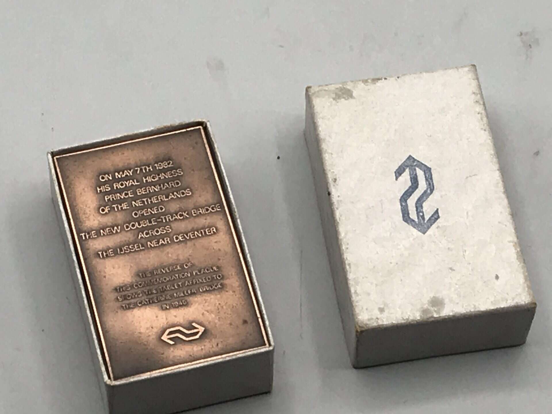 Bronze commemorative railway plaque displayed inside original Nederlandse Spoorwegen presentation box, lid marked with NS logo