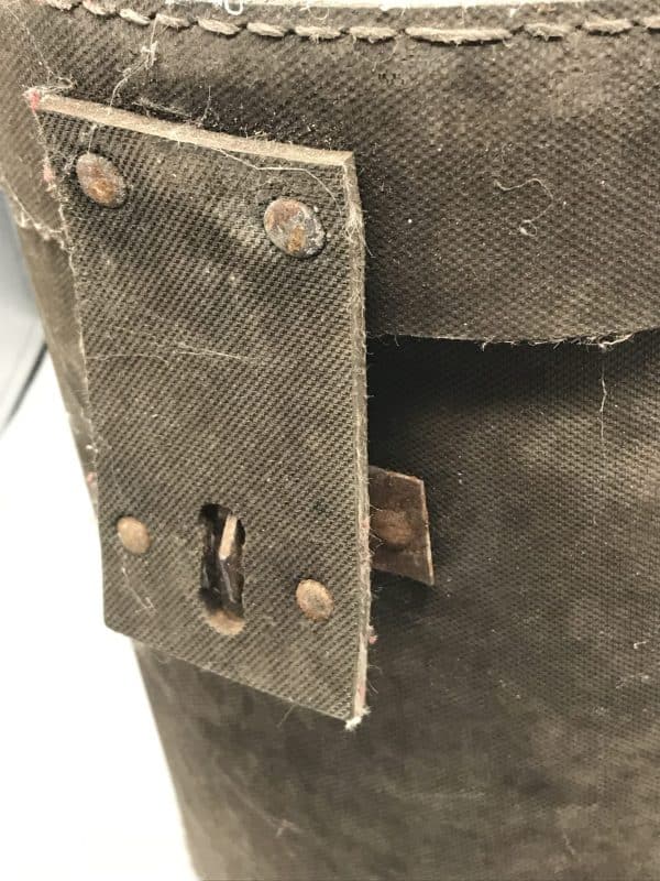 Close-up of replacement locking clasp and riveted canvas flap on early 20th century mining explosives canister