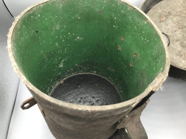 Interior view of early 20th century mining explosives canister showing green painted lining and riveted construction
