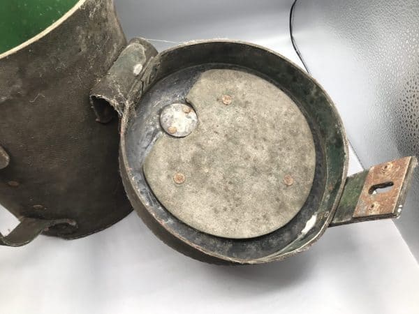 Interior of lid from early 20th century mining explosives canister, showing riveted disc and green-painted inner surface