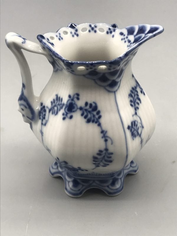 Elevated side view of 1960s Royal Copenhagen porcelain cream jug in Blue Fluted Lace pattern, showing rim and floral detailing