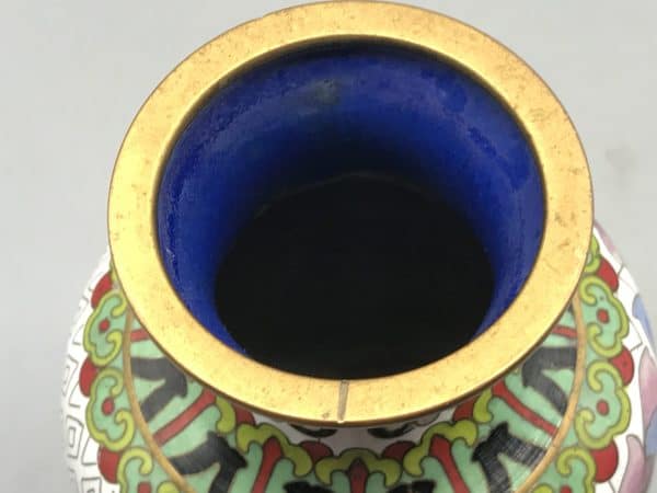 Close-up of top rim on vintage Chinese cloisonné vase with enamel interior and floral collar