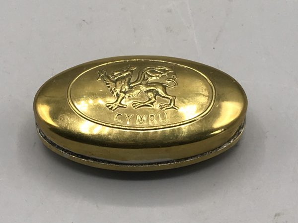 Brass snuff box with embossed Welsh dragon and "CYMRU" text on the lid.