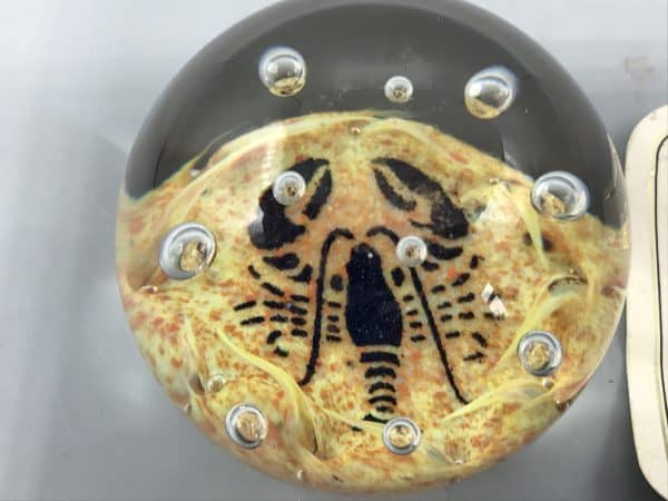 Close-up of Caithness glass lobster paperweight with stylized sea life motif and suspended air bubbles