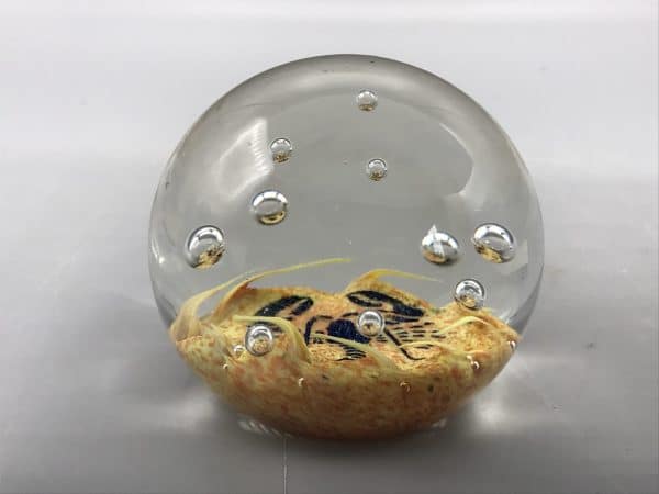 Side view of Caithness glass lobster paperweight showing internal bubble detail and sandy base