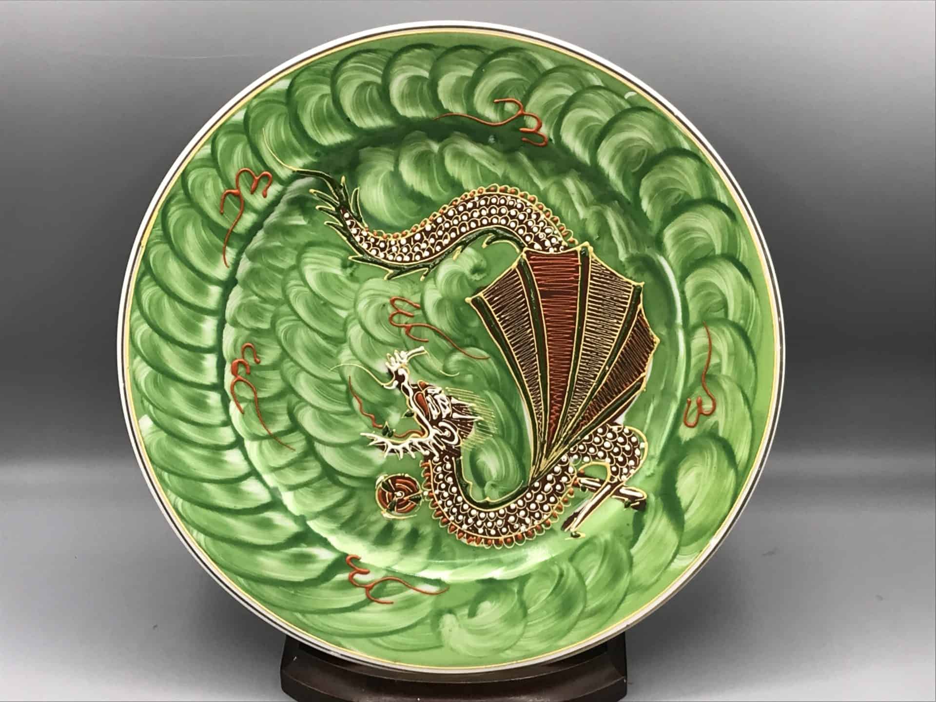 Vintage Japanese porcelain plate with green swirl background and raised moriage dragon design, measuring 10 inches in diameter
