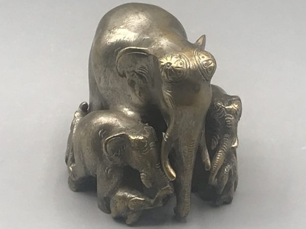 Early 20th-century Indian antique brass elephant family sculpture front view featuring central matriarch and surrounding calves, with worn silvered finish, approximately 3.75 inches tall