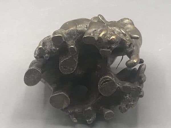 Early 20th-century Indian antique brass elephant family sculpture underside view showing the flat unmarked base with casting details and remnants of original silver wash, about 3.75 inches tall