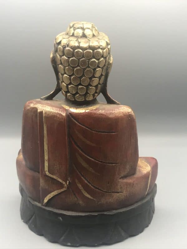 Back view of antique hand-carved wooden Buddha statue with gold gilt and red accents, showing detailed robe carving and textured hair curls, approximately 12 inches tall