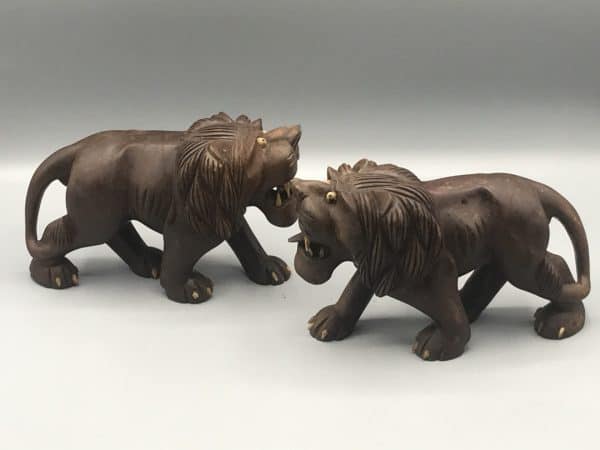 Side view of carved wooden Chinese guardian lions pair, known as foo dogs, facing each other with open mouths and detailed manes, measuring about 7 inches long and 4.35 inches tall.