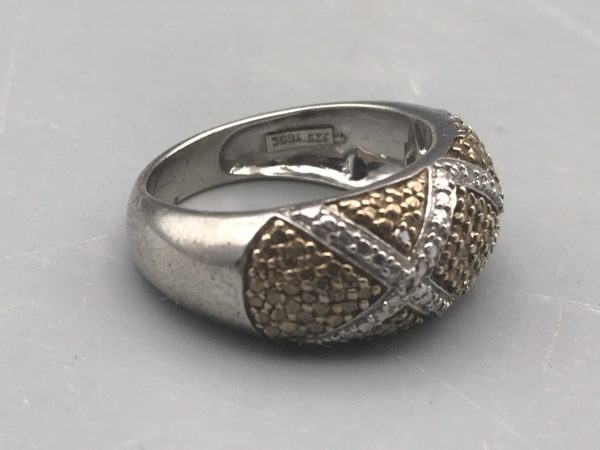 Sterling silver two-tone ring by TGGC with gold textured panels and crisscross silver bands, marked 925, shown from side angle highlighting maker’s mark inside the band.
