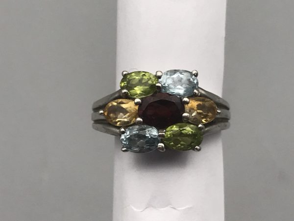 Front view of a sterling silver 925 multi-gemstone ring featuring oval-cut garnet, citrine, peridot, and blue topaz in a symmetrical floral cluster design.