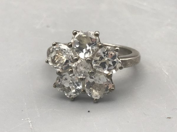 Side view of vintage sterling silver TGGC cluster ring showing floral setting and curved band