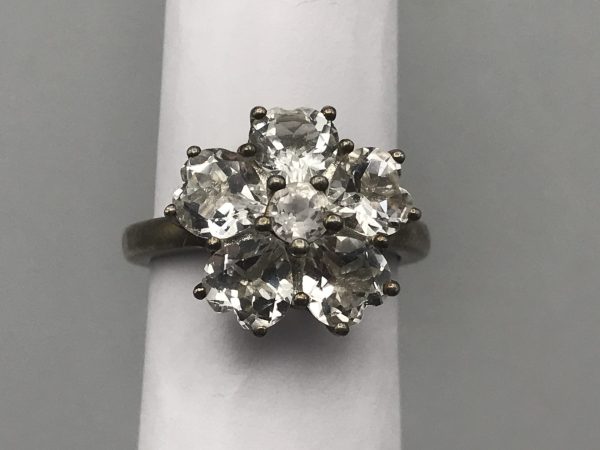 Top view of vintage sterling silver TGGC cluster ring with clear petal-cut stones arranged in a floral design, size Q
