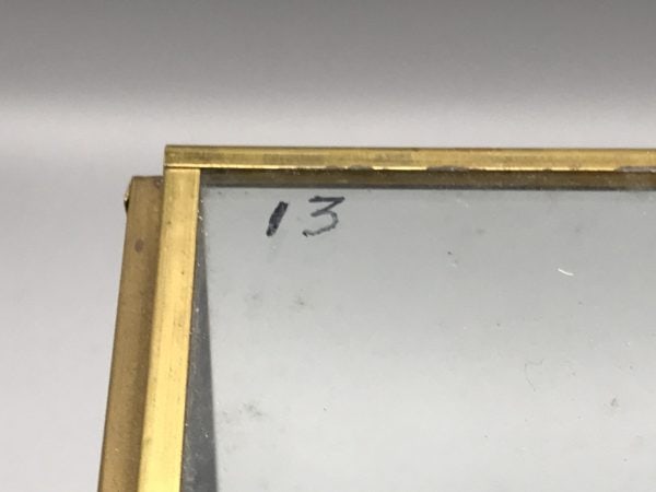 Close-up of number “13” handwritten in marker on the brass and glass display case of the Danbury Mint 1938 Rolls-Royce Phantom III model