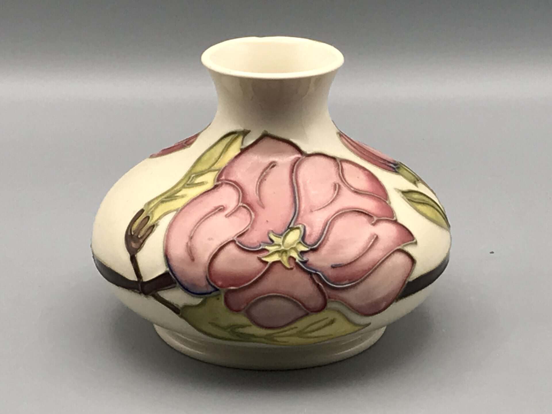 Moorcroft Magnolia vase, hand-painted and tube-lined ceramic with pink magnolia flower and green leaves on a cream ground, 4 inches tall.