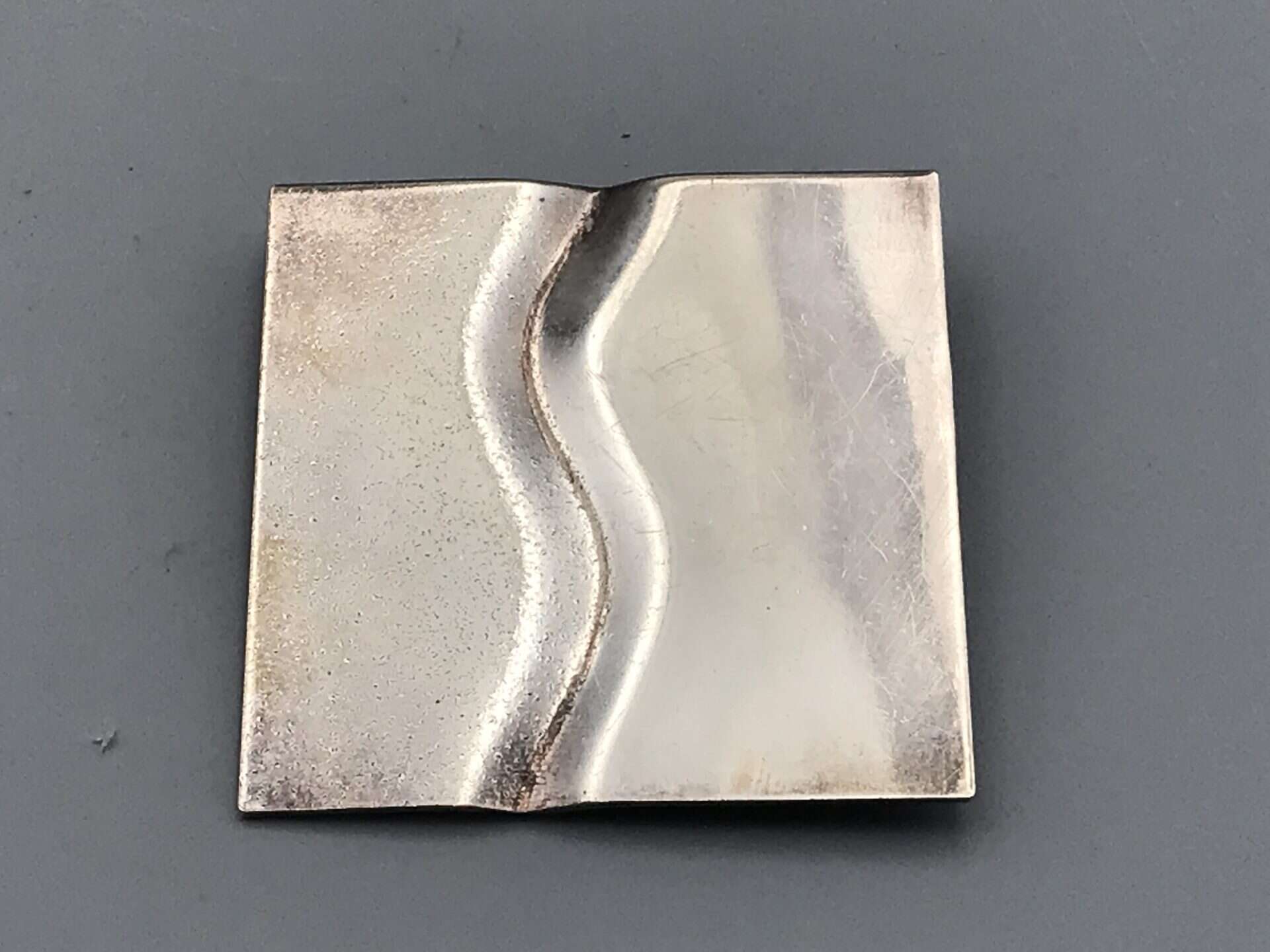 Modernist sterling silver square brooch with abstract folded-wave design, Birmingham hallmarked, approximately 2 inches by 2 inches