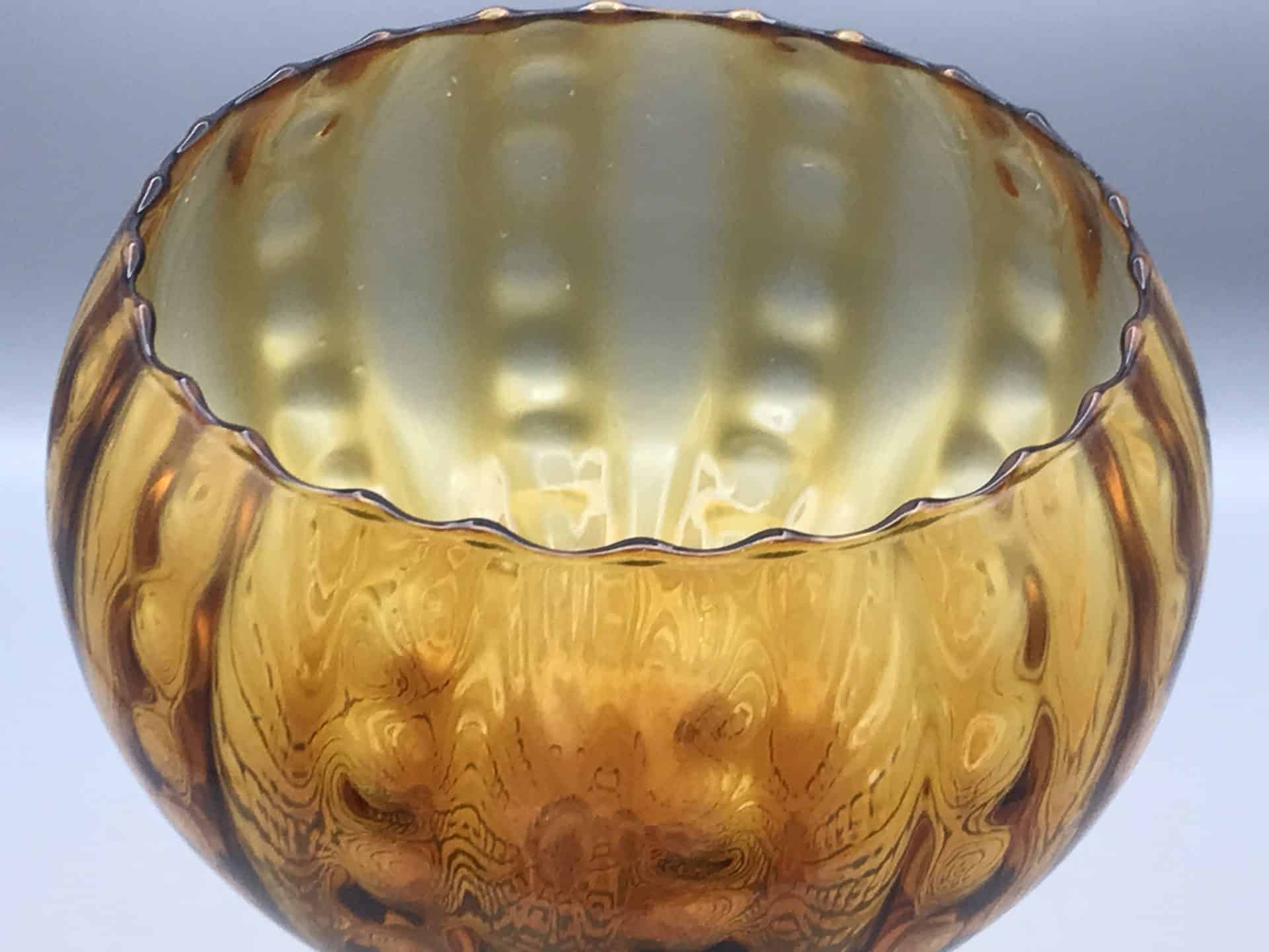 Close up of mid century Empoli amber glass vase showing ribbed bowl and scalloped rim