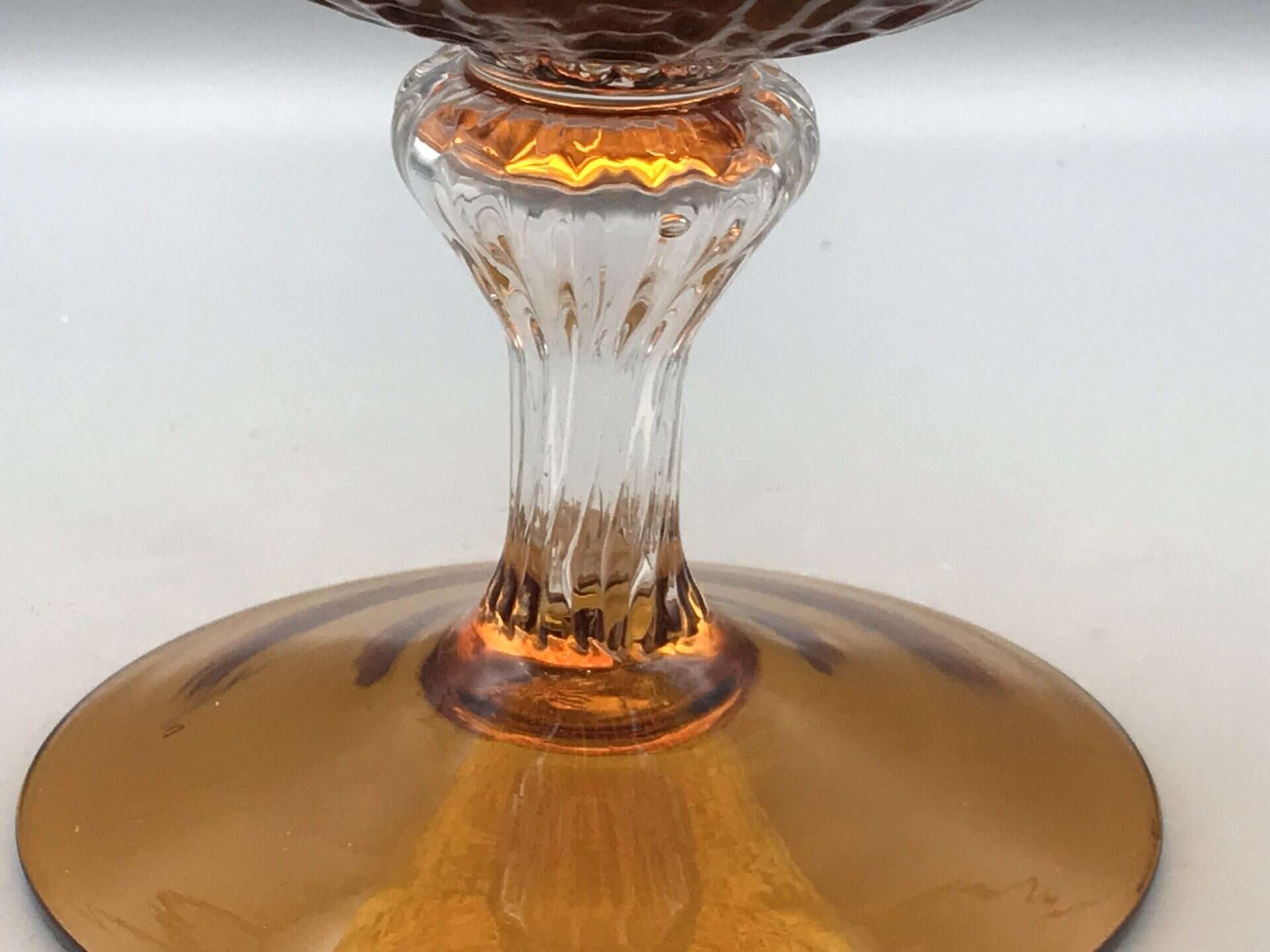 Close up of mid century Empoli glass vase showing clear moulded stem and amber foot
