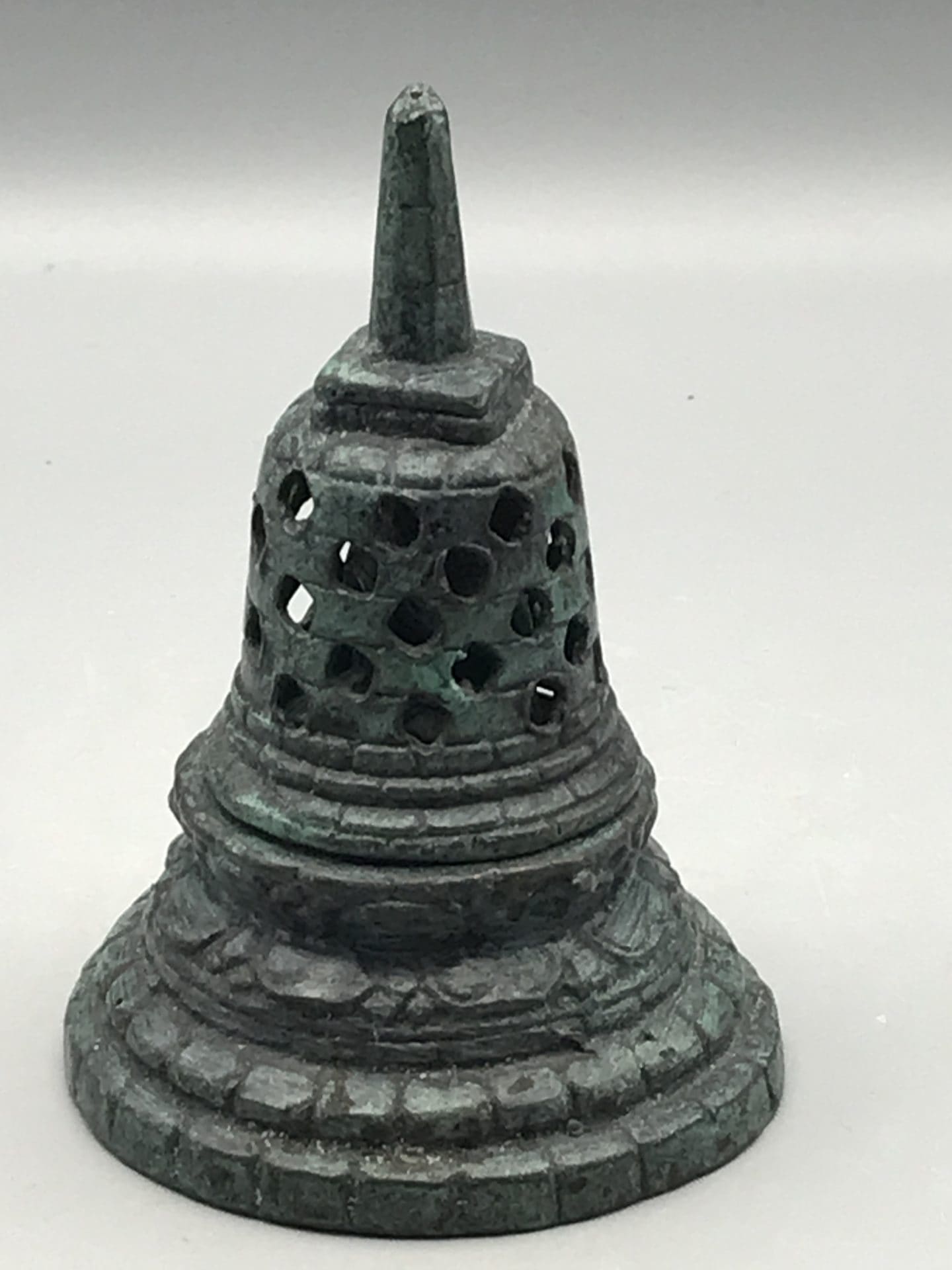 Bronzed base metal Buddhist stupa-form bell with pierced cover, approximately 4.75 inches tall, shown in full view.