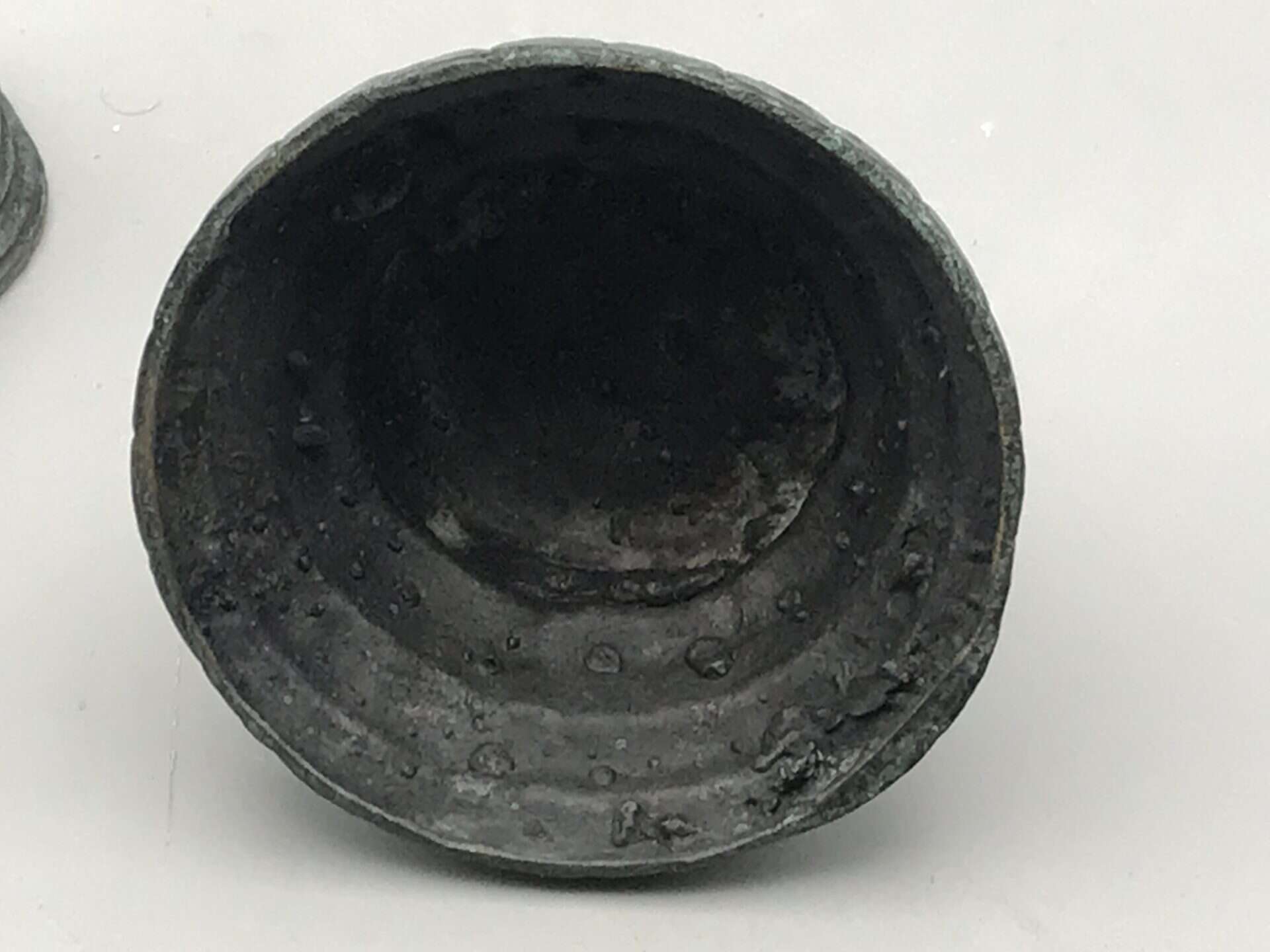 Interior view of the bronzed base metal stupa bell, showing the hollow base with aged and textured metal surface.
