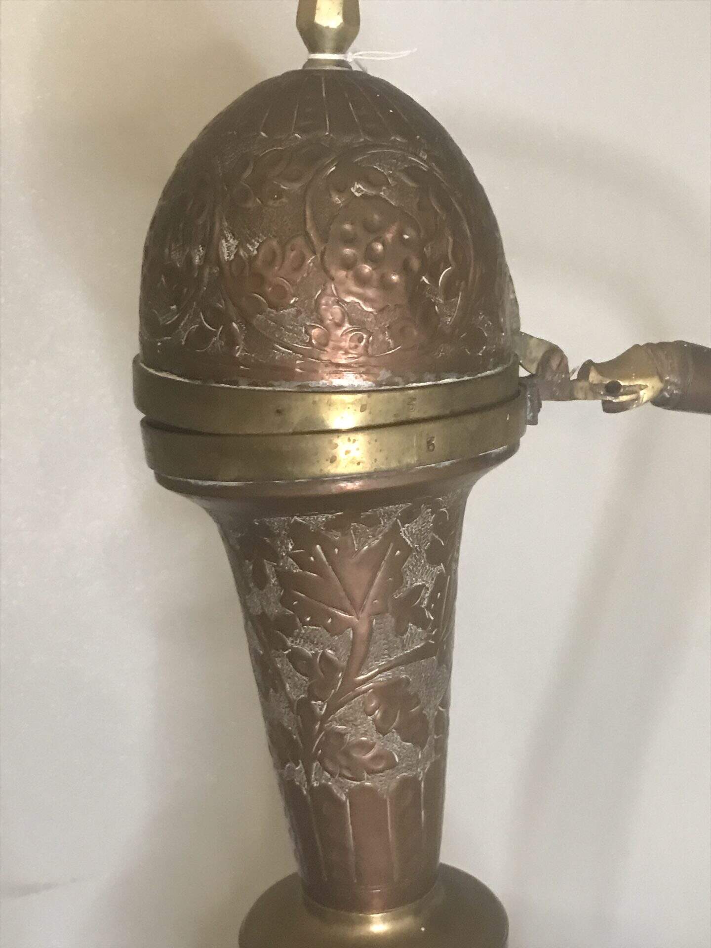 Close-up of the bulbous body of a monumental Ottoman copper ewer showing deep floral repoussé decoration with central medallion, late 19th century hand-raised metalwork