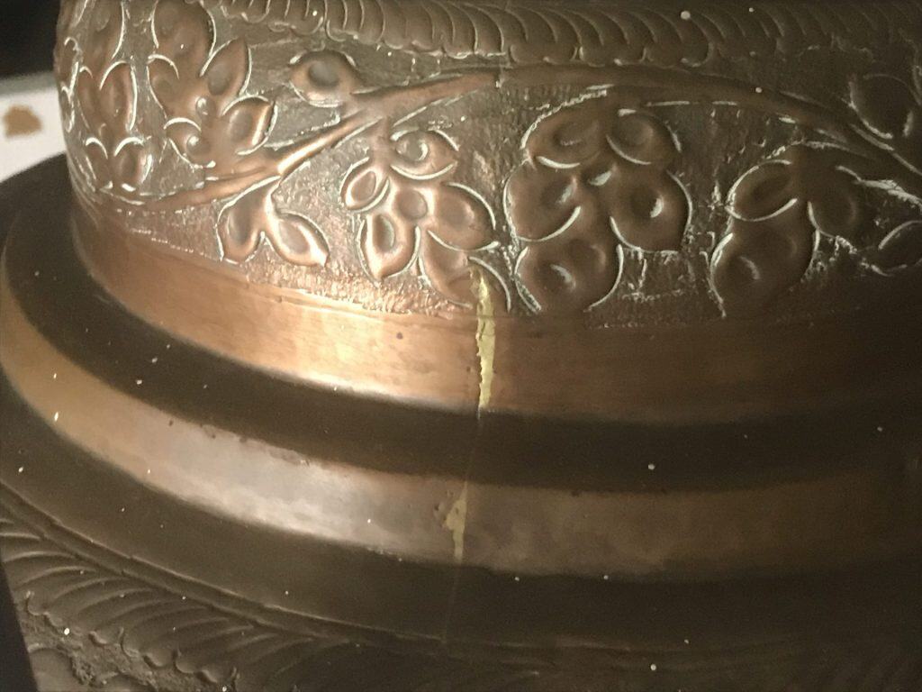 Vertical soldered seam on the bulbous body of a monumental Ottoman copper ewer showing hand-raised floral repoussé decoration and multi-section construction
