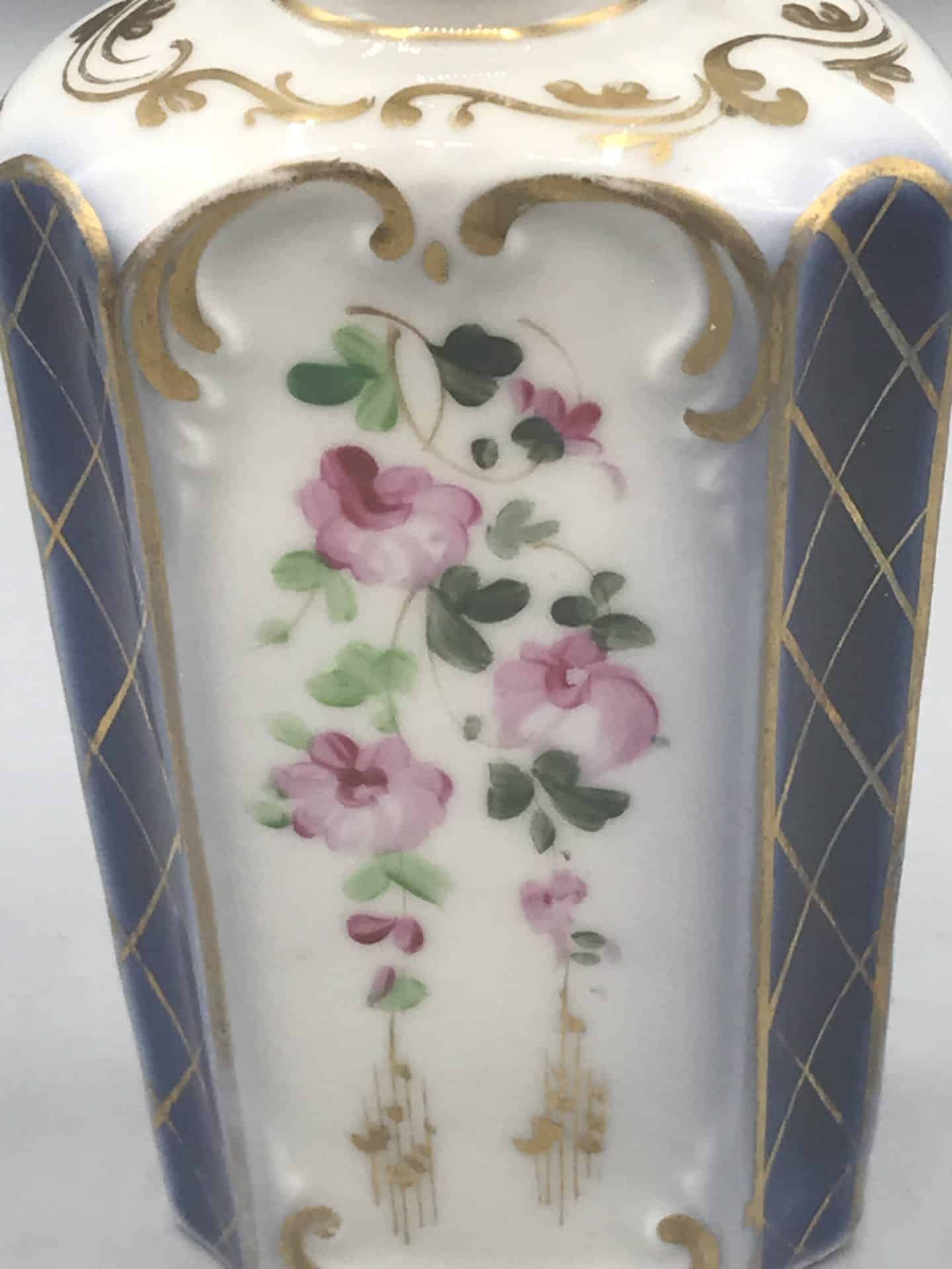 19th century French porcelain scent bottle detail with hand painted pink floral panel, gilt framing, and cobalt blue ground
